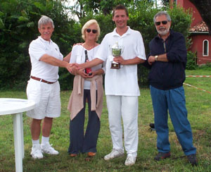 Photo of four people at the presentation for the Italian Open, with John Moore holding the trophy.