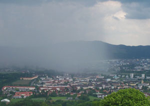 Photo of a storm cloud over much of Linz, but with other parts of the city clearly visible.